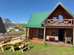a wooden cabin with benches in front of it at Chalet Hill Mountain Sauna in Žabljak