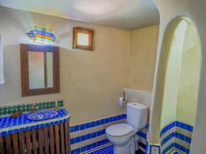 a bathroom with a toilet and a mirror at Riad Atlas Imlil in Imlil