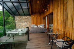 a room with a bed and a tub on a deck at Cabañas Hoja Verde in Monteverde Costa Rica