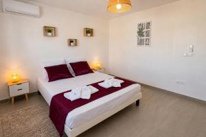 a bedroom with a bed with towels on it at Villa Noyanny Piscine Privée Calme in Le Moule +12 photos