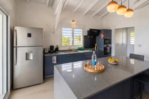 a kitchen with a stainless steel refrigerator and a counter at Villa Noyanny Piscine Privée Calme in Le Moule