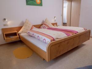 a bedroom with a wooden bed with pillows on it at Terrassenwohnung, Herrischried in Herrischried