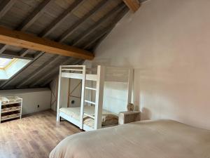 a bedroom with a white bunk bed and a window at Le 36 du prieuré in Arbois