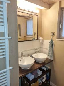 a bathroom with two sinks and a mirror at Chambres d'hôtes " Casa della Felicità " in La Roche-sur-le-Buis