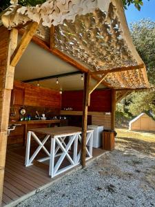 an outdoor kitchen with a table on a deck at Bocana Camping Borsh in Borsh