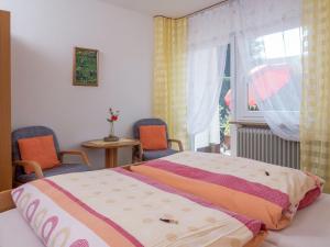 a bedroom with a bed and two chairs and a window at Terrassenwohnung, Herrischried in Herrischried