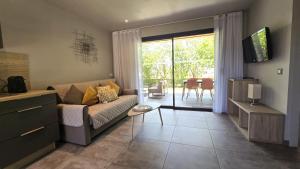 a living room with a couch and a sliding glass door at Domaine Lantana in Porto-Vecchio