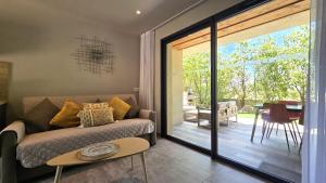 a living room with a couch and a sliding glass door at Domaine Lantana in Porto-Vecchio