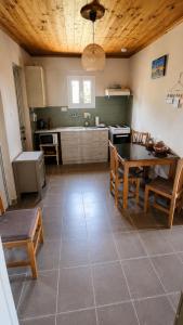 a kitchen with a table and some chairs and a table and a tablektop at Olive holiday home in Laganas