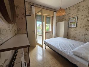 a small bedroom with a bed and a window at Manuela in Bibione
