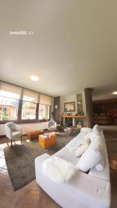 a living room with a white couch in a room at Hotel Sorriso in Ponte di Legno