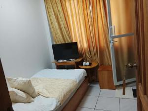 a bedroom with a bed and a television on a table at Dream Garden Hotel in Solano
