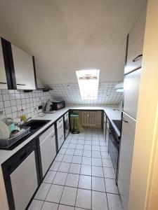 a large kitchen with white tile floors and a window at Kurzzeitvermitung Angelov in Hameln