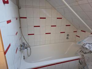 a bathroom with a white tub and red and white tiles at Kurzzeitvermitung Angelov in Hameln +10 photos