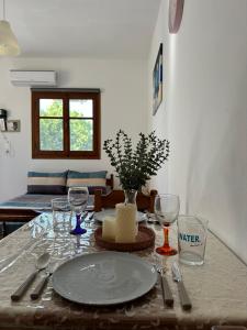a table with a plate and wine glasses on it at SDROSOS Apartment in Kos