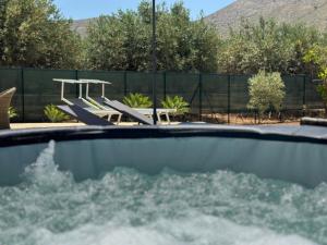 a swimming pool with chairs and a table at Villa Tosto in Castelluzzo