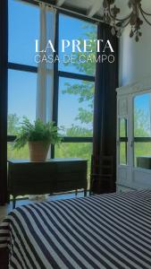 a bedroom with a bed and a large window at La Preta, casa de campo in San Clemente