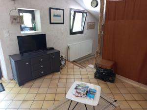 a living room with a tv and a table at Gîte à la campagne in Laborel