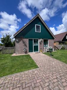 a house with a green roof and a brick yard at Zijperbries in Oudesluis