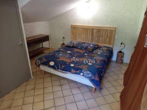 a bedroom with a bed with a blue comforter at Gîte à la campagne in Laborel