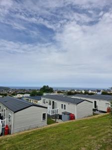 a row of mobile homes on a grassy hill at Caravan 63 Fishguard Holiday Park in Fishguard