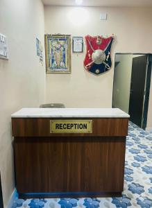 a reception desk with aederation sign on a wall at Radhe House in Dwarka