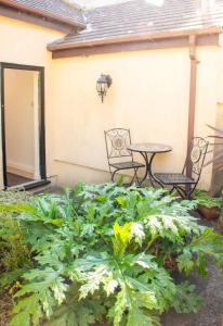 a patio with a table and chairs and plants at Eagles Nest - By Rowes Retreats in Falmouth