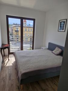 a bedroom with a bed and a large window at Grunwaldzka 62 in Bydgoszcz