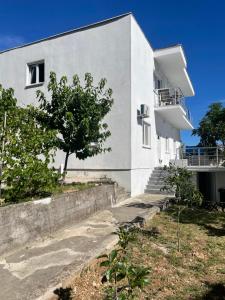 a white building with a tree in front of it at Mariyka Apartaments 2 in Sutomore