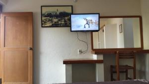 a flat screen tv on a wall next to a mirror at Hotel Avenida Ixmiquilpan in Ixmiquilpan