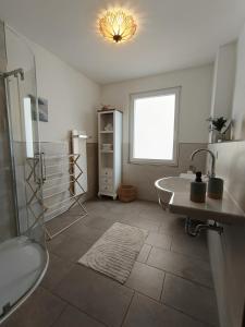 a bathroom with a sink and a tub and a shower at Ferienwohnung Florentine mit 2 Schlafzimmern in Bad Klosterlausnitz