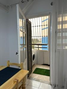 a bedroom with a bed and a door to a window at appartement cozy in Kolea