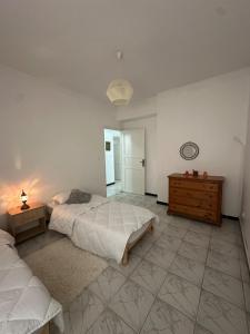 a bedroom with two beds and a wooden dresser at appartement cozy in Kolea