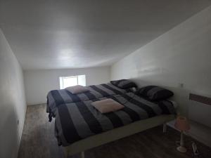a bedroom with a bed with a striped blanket at comfortable village house in Le Fossat +5 photos