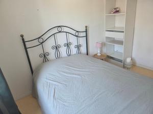 a bedroom with a bed with a white bedspread at comfortable village house in Le Fossat