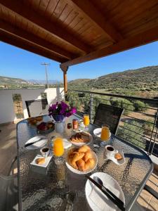 a table with food and orange juice on a balcony at Spacious 3bd Apartment in Lefkakia, Nafplio in Levkákia
