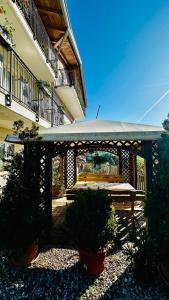 a gazebo with plants in front of a building at Agritur Due Valli in Livo