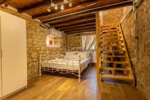a bedroom with a bed in a stone wall at Stefanos House in Afitos