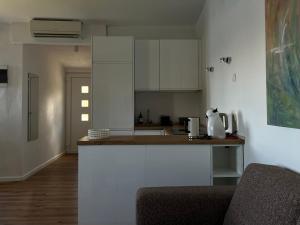 eine Küche mit weißen Schränken und einer Arbeitsplatte in der Unterkunft Apartment Rose in Rogač