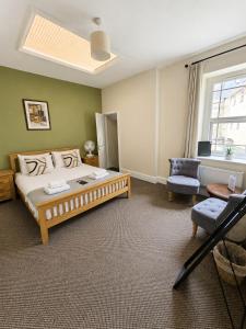 a bedroom with a bed and a chair and a window at The Cornerhouse in Frome