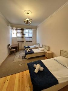 a bedroom with two beds and a table in it at STOP otel in Sheki