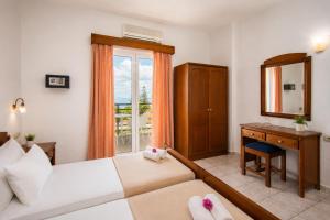 a bedroom with a bed and a desk and a mirror at Astir Studios in Stalís +23 photos