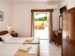 a hotel room with two beds and a desk at Astir Studios in Stalís