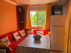 a living room with a red couch and a table at Mobil home devant un grenadier in Gémenos