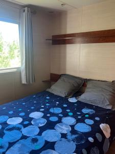 a bedroom with a bed with a blue flowered blanket at Mobil home devant un grenadier in Gémenos