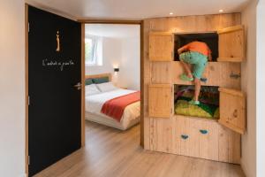 a person climbing into a bunk bed in a bedroom at Ô17 Séjour wellness avec bain nordique à 5 min de Namur in Namur