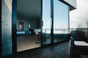 a room with a balcony with a view of the ocean at Casa do Horizonte in Ribeira Grande