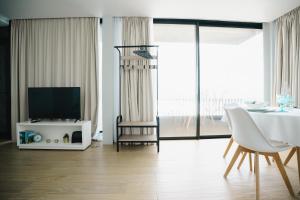 a living room with a television and a table with chairs at Casa do Horizonte in Ribeira Grande