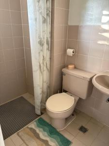 a bathroom with a toilet and a sink at CJ's Travellers Room in Maribago