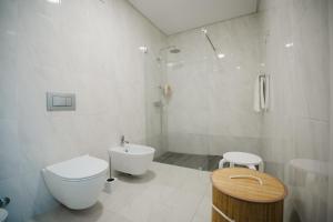 a white bathroom with a toilet and a sink at Casa do Horizonte in Ribeira Grande +12 photos